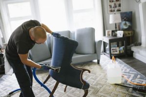 Photo of a woman performing spot removal on upholstery