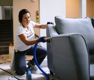 Photo of a woman using upholstery cleaning equipment